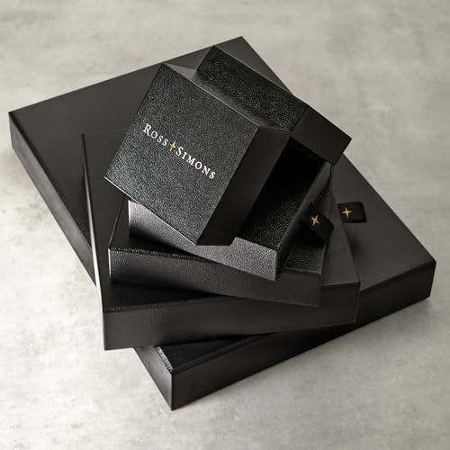 Stack of black gift boxes on a gray surface