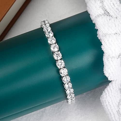 Elegant diamond bracelet displayed on a teal cushion