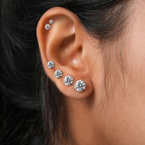 Close-up of ear with multiple diamond stud piercings