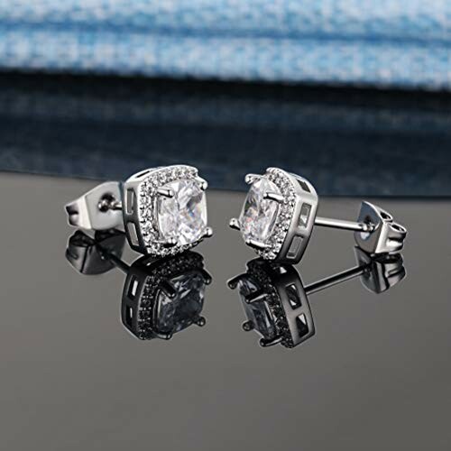 Silver diamond stud earrings on reflective surface