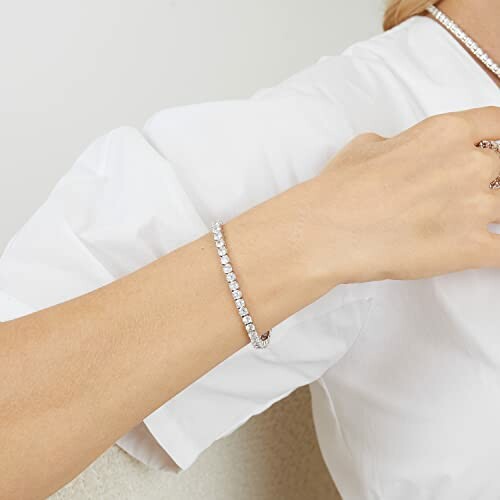 Woman wearing an elegant tennis bracelet on her wrist.