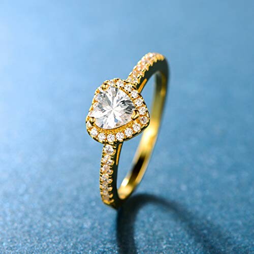 Gold ring with heart-shaped diamond on blue background