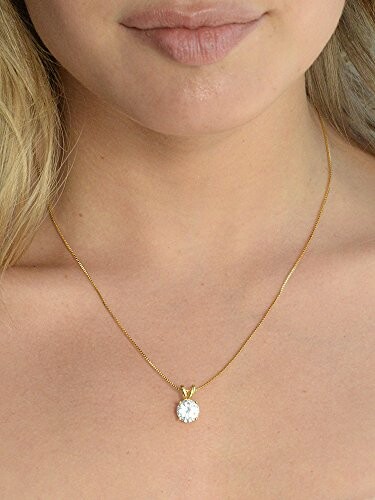 Woman wearing a gold necklace with a diamond pendant