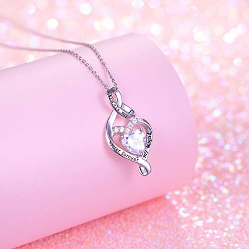 Heart-shaped necklace with gemstone on pink background