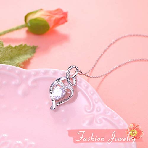 Heart-shaped pendant necklace on pink surface