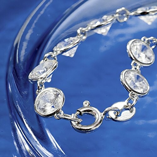 Silver bracelet with clear gemstones on a blue background.