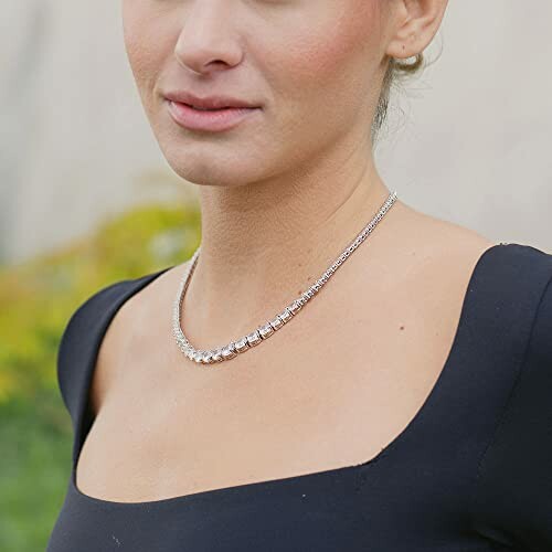 Woman wearing a silver necklace with a black dress