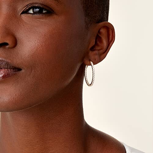 Close-up of a woman wearing a gold hoop earring.