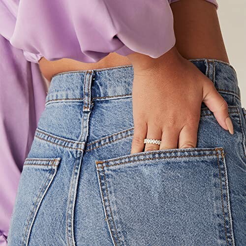 Woman's hand with rings in jeans pocket