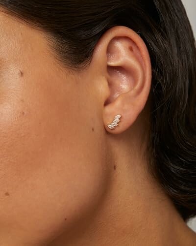 Close-up of a woman's ear with a small gold earring