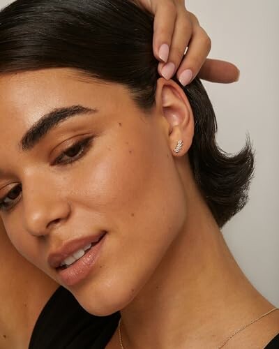 Woman with short hair wearing a small earring.