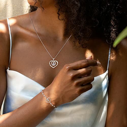 Woman wearing heart-shaped necklace and bracelet.