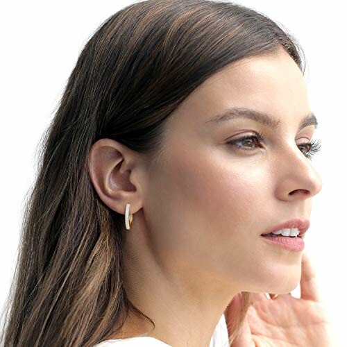 Woman with long brown hair wearing hoop earrings.