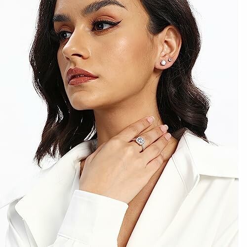 Woman with earrings and ring, wearing white shirt