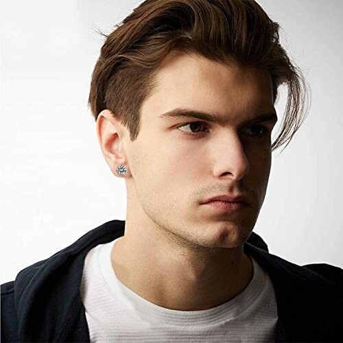 Young man wearing a stud earring, looking to the side.